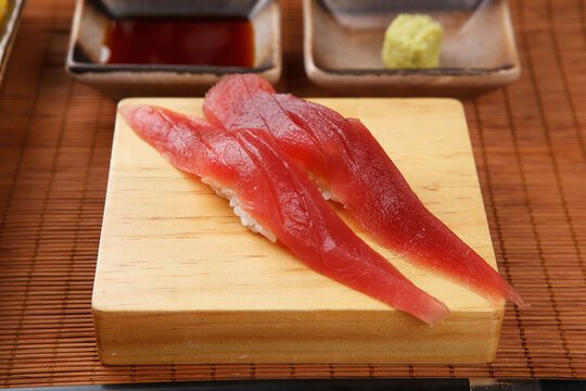 Fresh tuna nigiri sushi on a wooden serving board