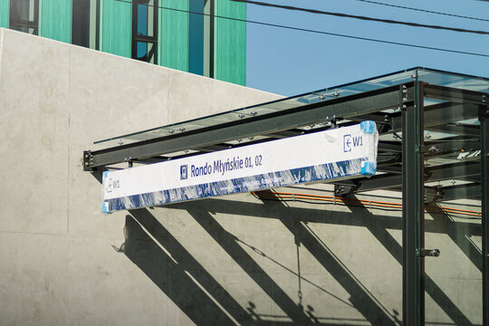 Horizontal urban infrastructure photo of modern bus stop sign and glass roof Rondo Mlynskie Krakow, Poland real photography