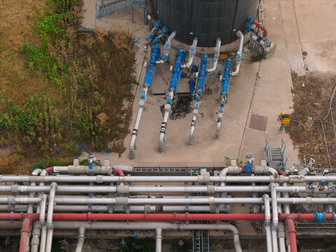 Aerial view of the wastewater treatment plant featuring complex industrial piping systems, valves, and concrete infrastructure in Wanlip, England, United Kingdom.