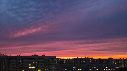 Fototapeta premium A bright red, orange, and blue sky over the city at sunset.