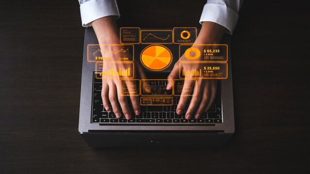 Person typing on laptop with glowing gold digital data dashboard interface overhead view