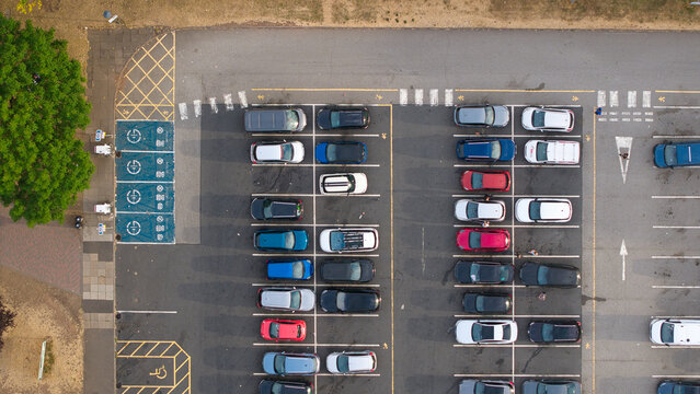 Aerial view of EV charging zones and parking lot at Corley Northbound Services on the M6 motorway, with parked cars and marked bays in Coventry, England, United Kingdom.