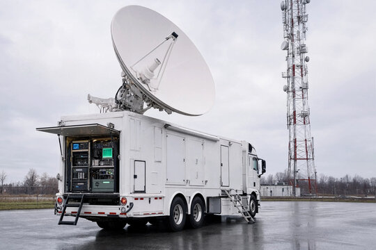 Mobile satellite uplink truck with large dish antenna for broadcasting and telecommunications.