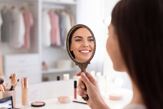 Woman looking in handheld mirror smiling reflection beauty care portrait
