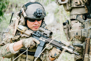 Naklejka premium Focused outdoor soldiers in jungle on duty show determination and serious emotion while patrolling during tactical training mission