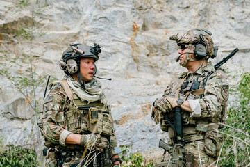 Serious soldiers in outdoor jungle on duty showing professional focus while wearing tactical gear...