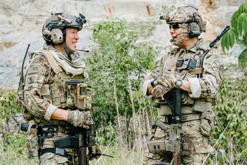 Naklejka premium Professional soldiers outdoor jungle soldiers on duty feel confident during friendly conversation in tactical forest training ground