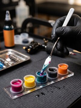 Tattoo Artist Mixing Colorful Inks at Professional Workstation Close-up