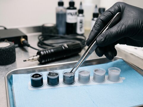 Close-up of Tattoo Artist Preparing Ink Cups in Studio