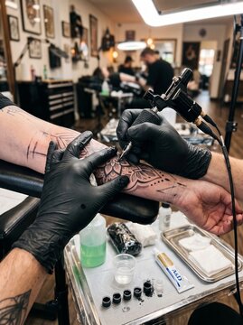 Professional tattoo artist creating dotwork mandala tattoo on forearm