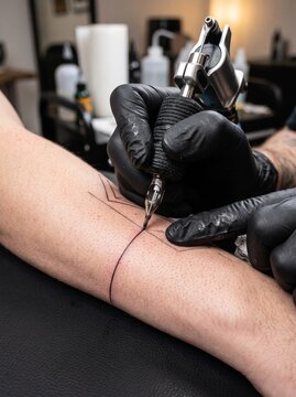 Close Up of Professional Tattoo Artist Working on Client's Arm