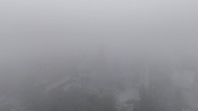 Holy Trinity Cathedral in Hajn&oacute;wka Emerging from Dense Fog, Aerial Drone View, Poland