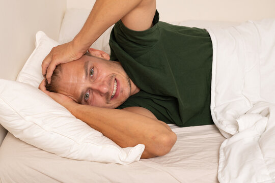 Man Suffering from Severe Headache While Lying in Bed