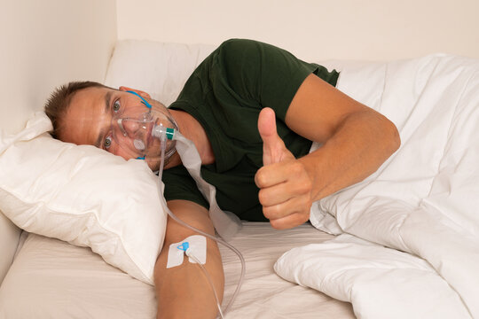 Sick Man Receiving Oxygen and Intravenous Therapy While Lying in Bed