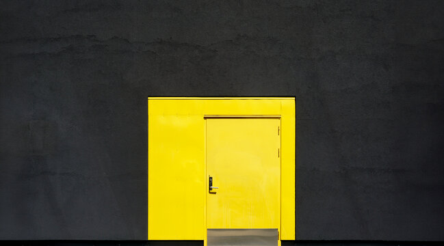 Yellow door on black wall minimalist architecture