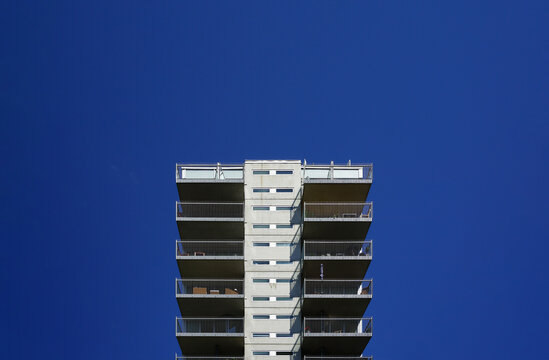 Modern apartment building balconies against deep blue sky in Oslo