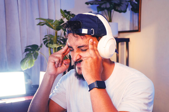 Man feeling stress and headache while working or gaming
