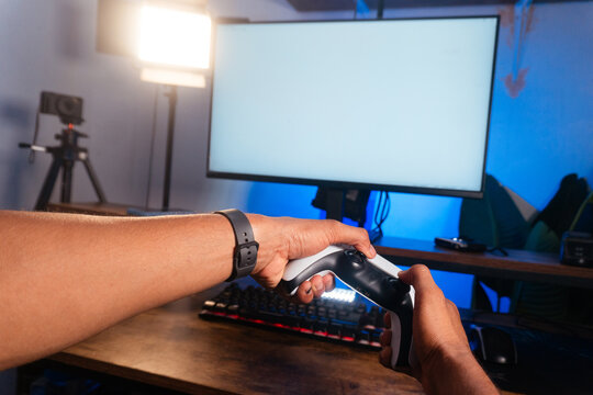 Person holding gaming controller playing online video games