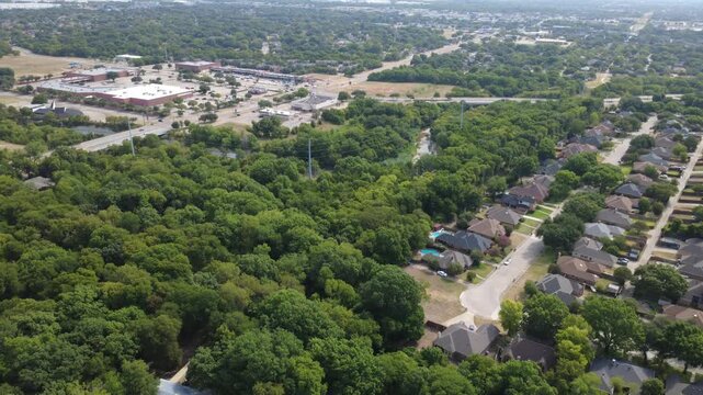 Leafy riparian woods border Ten Mile Creek near Pleasant Run Road in southern suburbs. Suburban cul de sacs, private lawns, retail centers illustrate harmonious municipal growth, DeSoto, TX