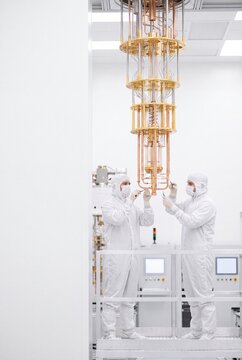 Deep tech engineers examining quantum computer hardware in cleanroom