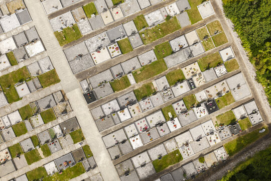 Aerial view of St Patrick's Church cemetery featuring rows of graves, stone markers, and manicured grass paths in Portlaw, County Waterford, Ireland.