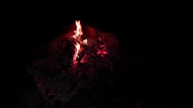 Burning embers in dark style in red and orange colors representing warmth and cozy winter nights