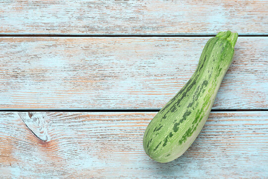 Fresh raw zucchini on wooden table, top view. Space for text