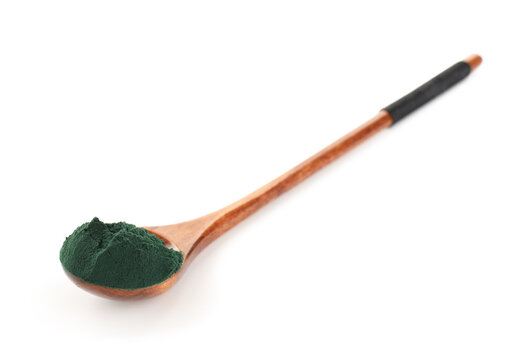 Natural spirulina powder in wooden spoon isolated on white