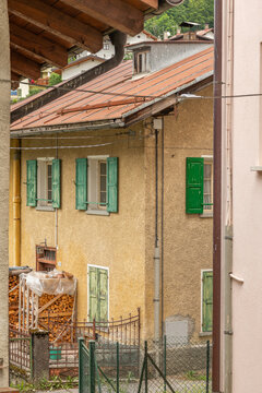 Alleghe, Italy. Traditional mountain house with green wooden shutters, firewood and rustic architecture in the Dolomites