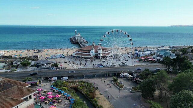Drone fly forward shot of Ferris wheel and iconic Bournemouth Pier England