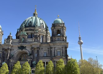 Berlin Cathedral Dome Close-Up with TV Tower and Green Trees Under Clear Blue Sky © Chris