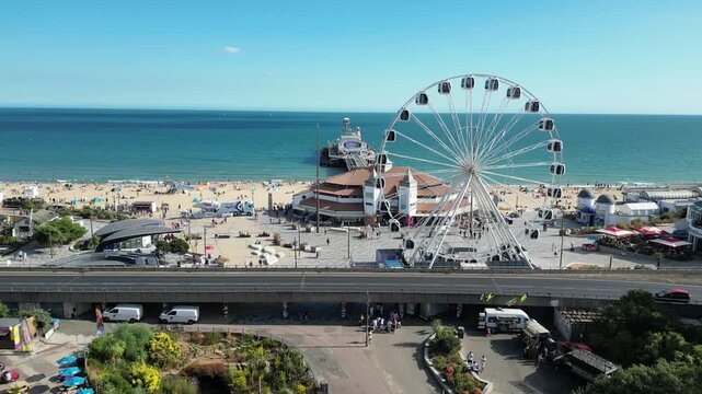 Static drone aerial of rotating Ferris wheel and traffic in Bournemouth England