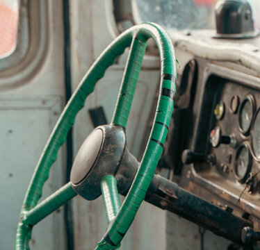 A close-up shot captures the worn dashboard and a vintage truck steering wheel wrapped completely in green electrical tape.