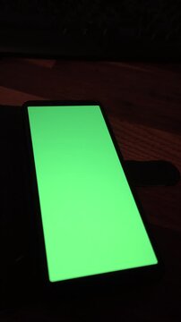 Smartphone mit Green screen und dunklem Holz Hintergrund Mock Up 4K 30fps
