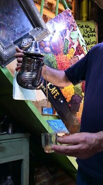 Marrakech, morocco. August 8, 2026. Man's hands pouring traditional hot mint tea from a silver teapot into a glass in a marrakech souk. Authentic moroccan hospitality ritual