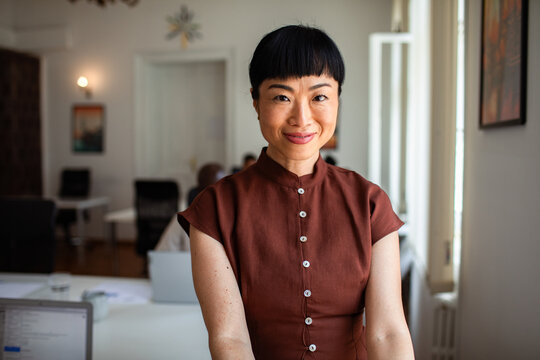 Confident professional woman smiling in bright coworking office