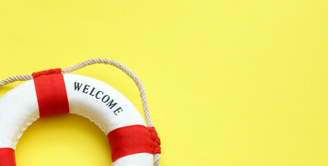 Life buoy on yellow background with copy space for summer travel and safety concept © roobcio