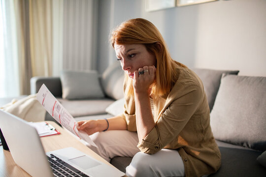 Worried woman reviewing bills at home