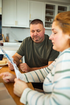 Worried couple reviewing household bills at home kitchen