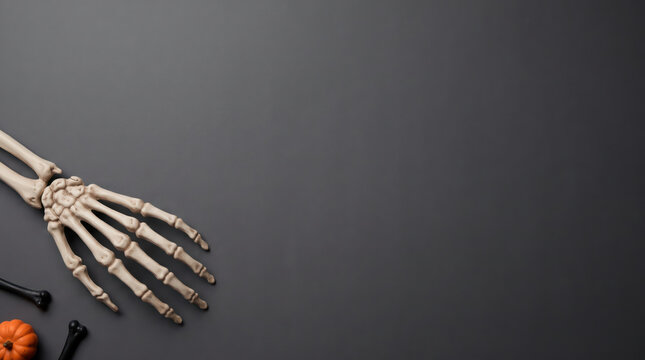 Human skeleton hand with pumpkin and bullets