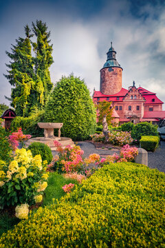 Wonderful summer view of tower of Czocha Castle and blooming flower on foreground. Sunny morning scene of Sucha village, district of Gmina Lesna,  Poland, Europe. 