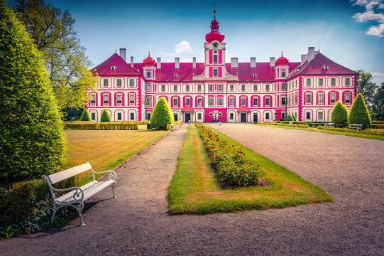Colorful morning view of Mnichovo Hradiste palace with green meadow, flowerbed and white sit. Wonderful summer cityscape of Mnichovo Hradiste town, Europe. Traveling concept background.