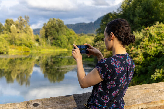 Woman Taking Photo With Smartphone At Great Blue Heron Nature Reserve In Chilliwack BC Canada