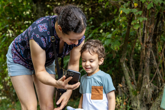 Mother and Son Looking at Phone Together Outdoors at Great Blue Heron Nature Reserve, Chilliwack BC