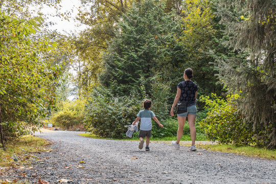 Mother and Son Walking Together on a Forest Trail at Great Blue Heron Nature Reserve in Chilliwack BC Canada