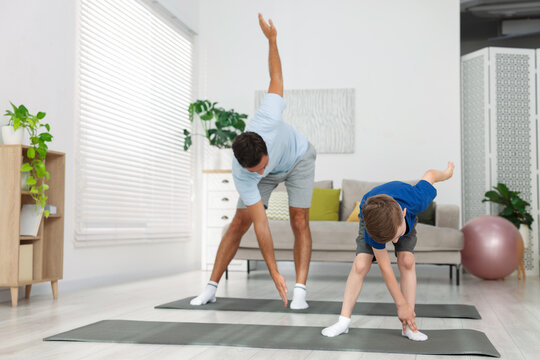 Father and his son doing exercise together at home