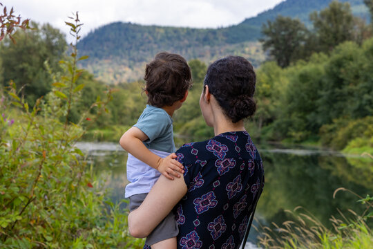 Mother Holding Young Son Overlooking Lake and Forest at Great Blue Heron Nature Reserve in Chilliwack