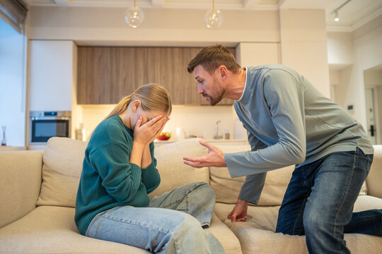 Hysterical suspicious husband accusing shocked and scared wife, couple in emotional family conflict, nervous jealous man partner yelling at woman partner, infidelity mistrust and mental frustration.