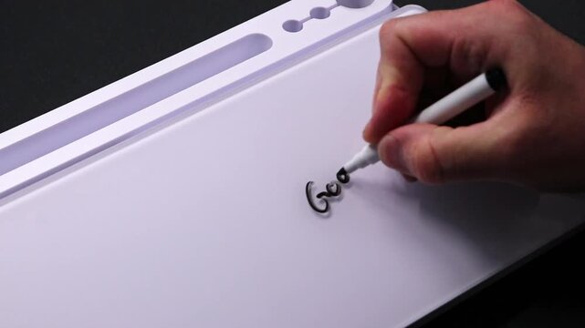 European male hand writing good work on whiteboard with black pen and erases it with white sponge afterwards for seamless looping message writing on whiteboard. Positive feedback from boss great work.
