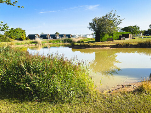 A pond in a holiday park, a relaxing scene with camping pods in the background